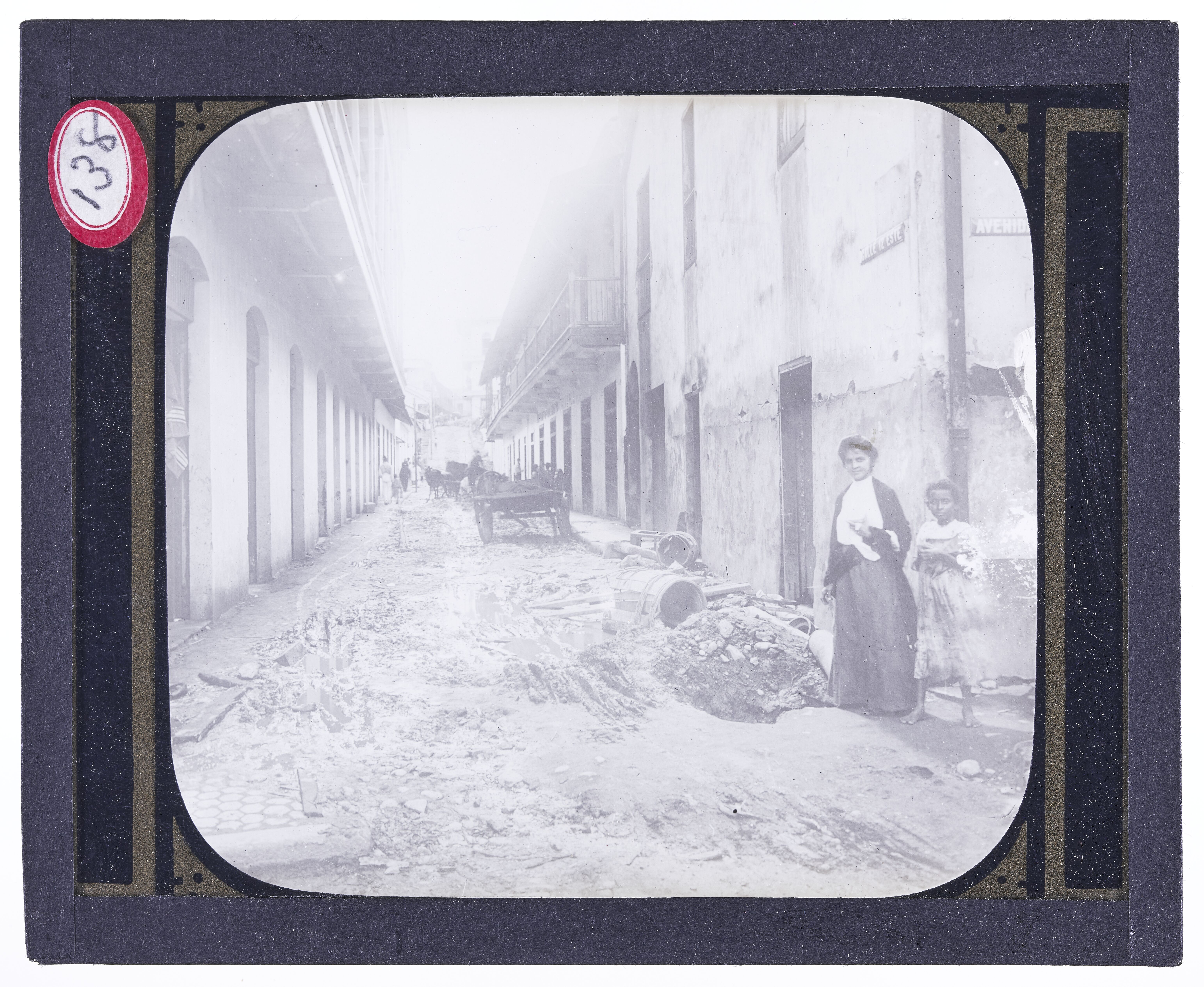 A woman and a girl standing in a damaged street in an unnamed town