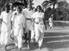 Gandhi walking with Manu Gandhi and Amtul Salaam